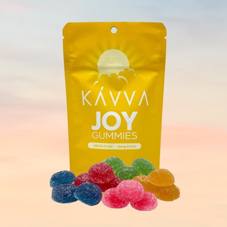 joy-kavva-delta-9-thc-gummies-pile-in-front-packaging-sunrise-behind-packaging-kavva-2023